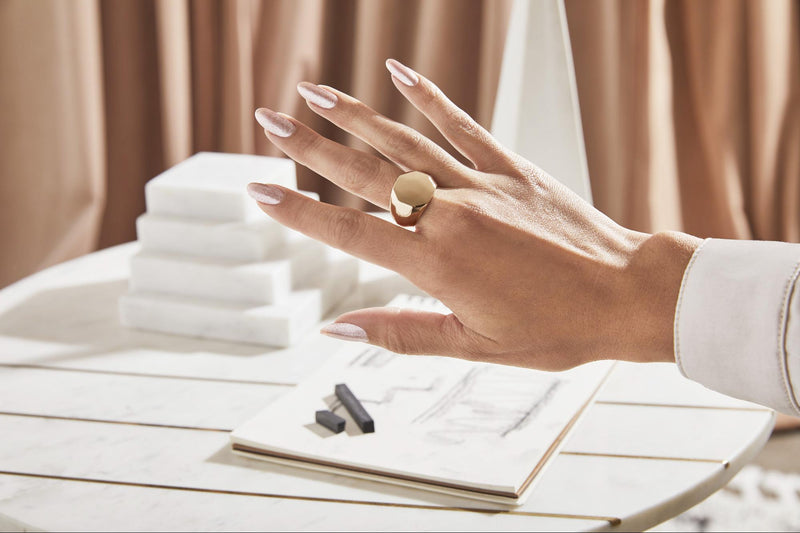 Hand with light gold nails and ring