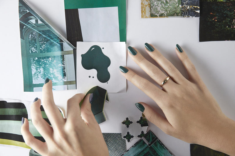 Hands with green nails making collage