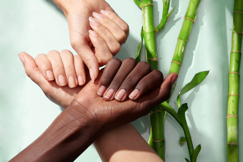 Three hands showing natural nails with bamboo